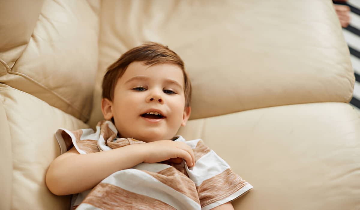 happy boy rests on a bed